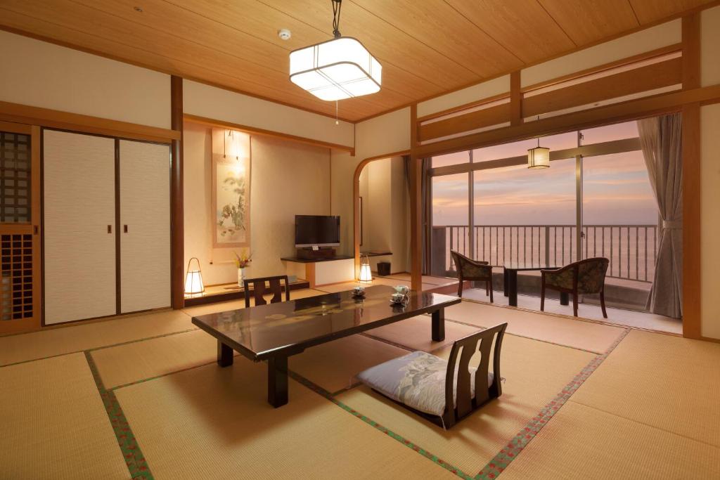 - un salon avec une table et une vue sur l'océan dans l'établissement Boyokaku, à Amakusa 10 autres photos