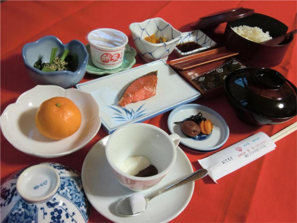 - une table avec des assiettes de nourriture et une tasse de café dans l'établissement Onsen Minshuku Sakaeya, à Shizukuishi 9 autres photos