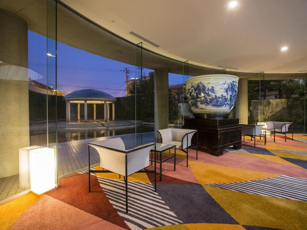 une chambre avec un grand vase sur une table et des chaises dans l'établissement APA Hotel & Resort Kaga Katayamazu Onsen Kasuikyo, à Kaga
