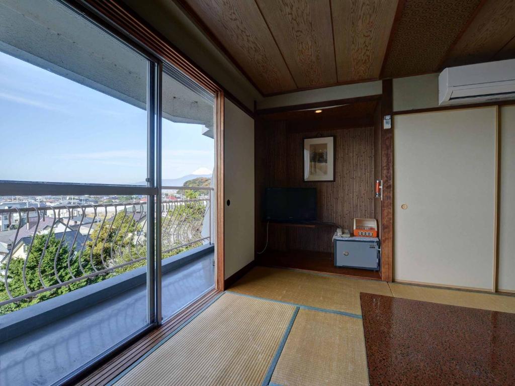 Cette chambre dispose d'une grande fenêtre offrant une vue sur la ville. dans l'établissement Suisenkaku, à Numazu 37 autres photos