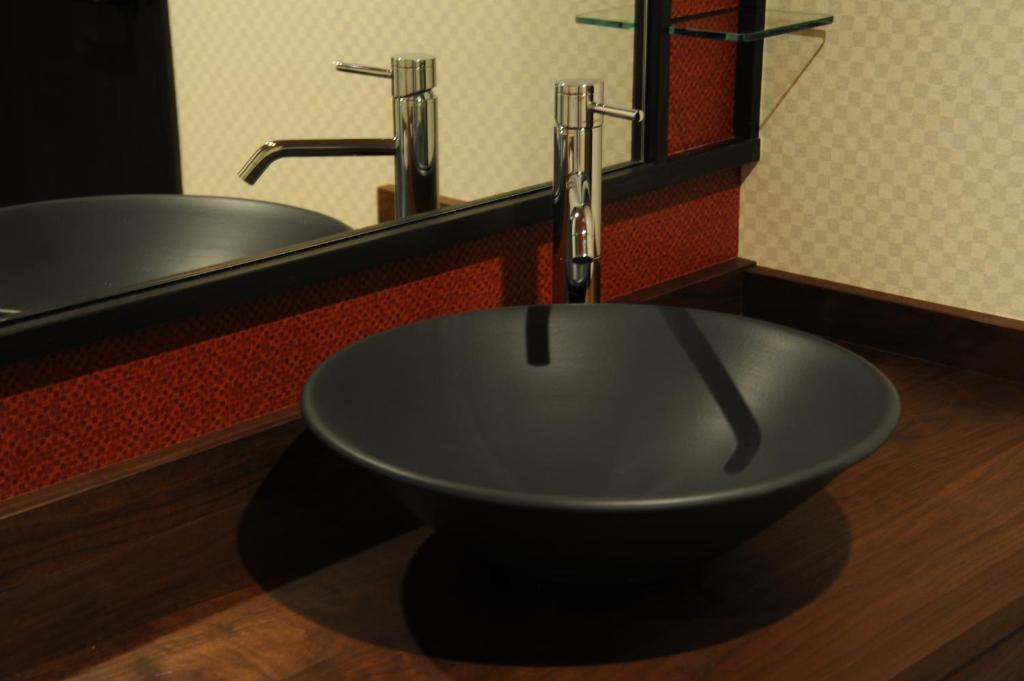une salle de bain avec un lavabo et un miroir dans l'établissement Kyoto Takasegawa Bettei, à Kyoto