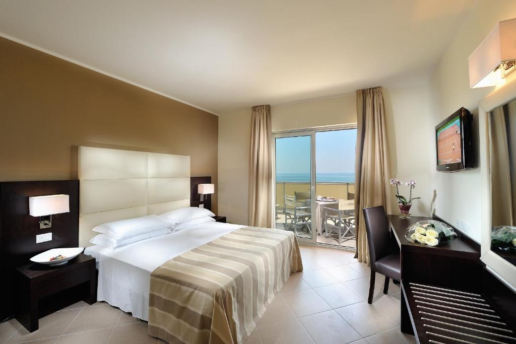 une chambre avec un lit et une vue sur l'océan dans l'établissement Hotel Excelsior, à Bibione