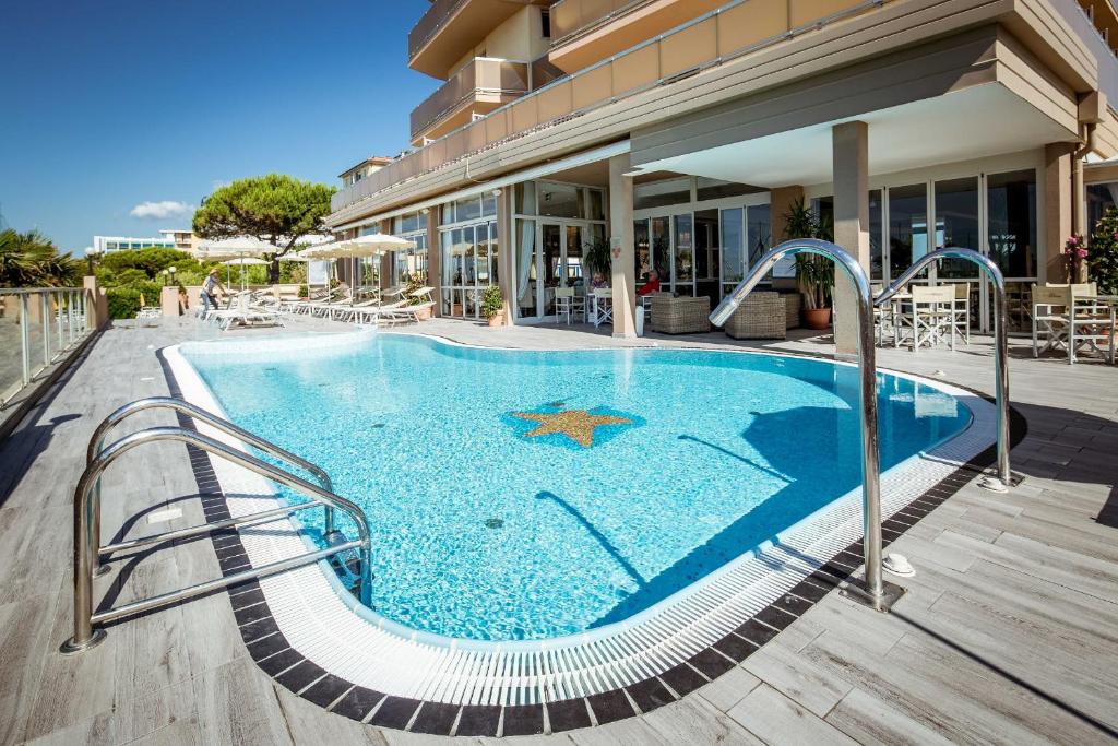 une piscine au milieu d'un immeuble dans l'établissement Hotel Excelsior, à Bibione