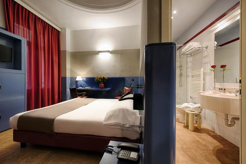 une chambre avec un lit et une salle de bain avec un lavabo dans l'établissement Hotel Italia e Lido Rapallo, à Rapallo