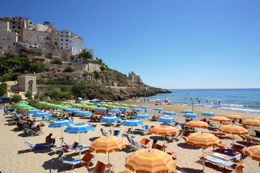 une plage avec beaucoup de parasols et de monde dessus dans l'établissement Hotel Mayor, à Sperlonga