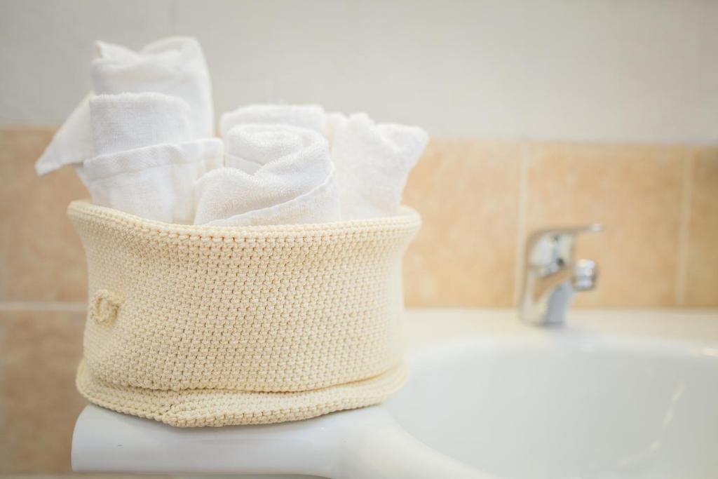 - une corbeille de papier toilette assise sur un lavabo dans l'établissement Hotel Royal, à Bibione