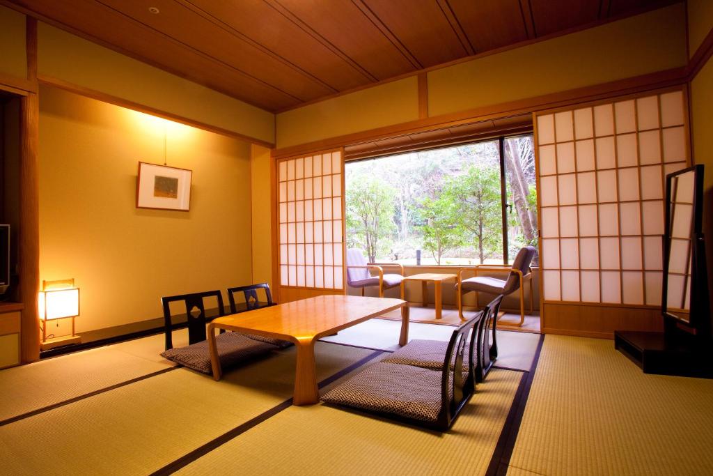 une pièce avec une table, des chaises et une fenêtre dans l'établissement Ranzan, à Kyoto