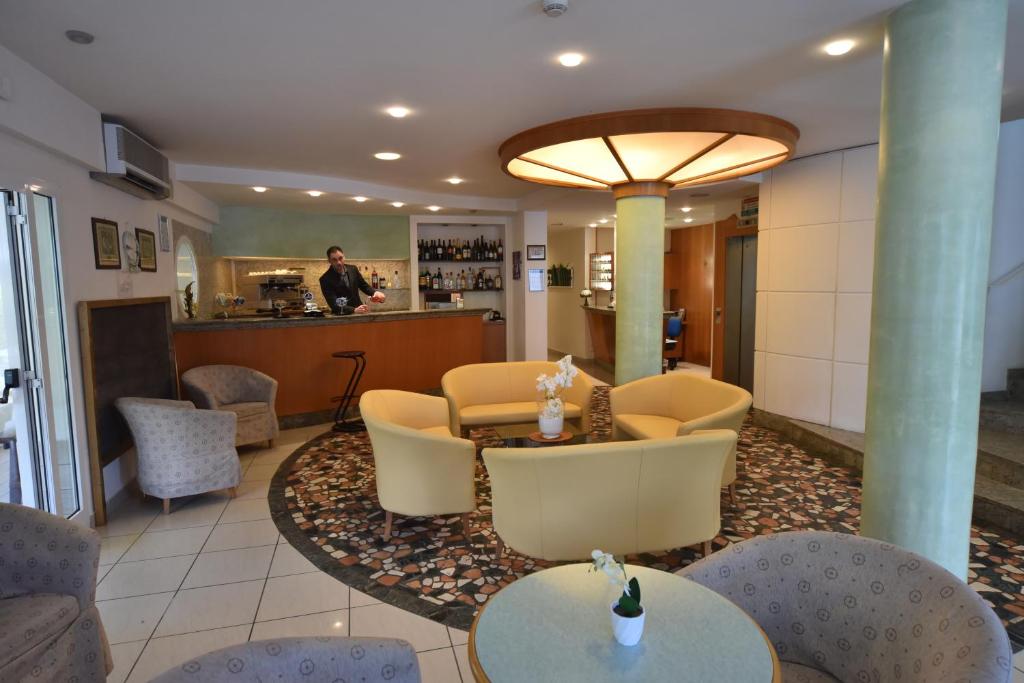 - un hall avec des tables et des chaises et un homme dans la cuisine dans l'établissement Hotel Marina, à Riccione
