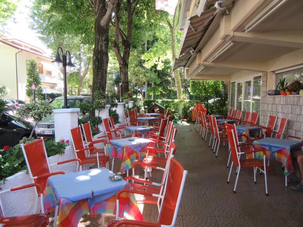 une rangée de tables et de chaises sur une terrasse dans l'établissement Hotel Urania Nuova Gestione, à Rimini