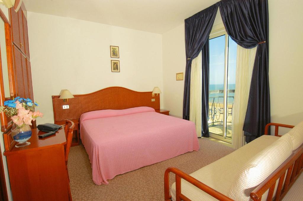 - une chambre avec un lit rose et un balcon dans l'établissement Hotel Beny, à Lido di Jesolo 49 autres photos