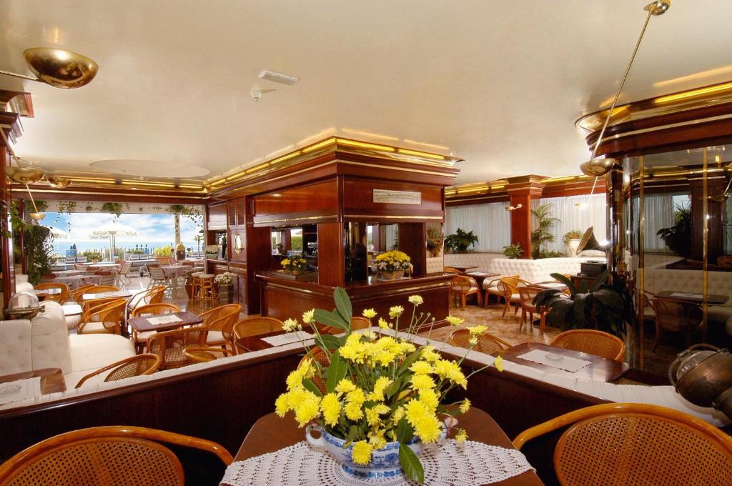 un restaurant avec une table ornée de fleurs jaunes dans l'établissement Hotel Beny, à Lido di Jesolo
