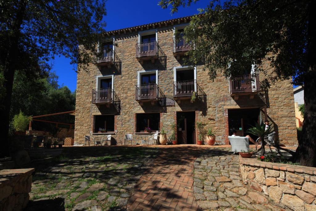 Elle offre une vue extérieure sur un grand bâtiment en pierre doté de balcons. dans l'établissement Nascar Hotel, à Santa Maria Navarrese