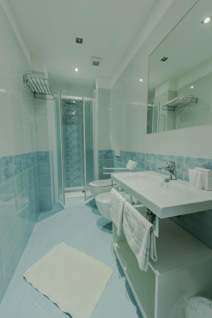 une salle de bain blanche avec un lavabo et des toilettes dans l'établissement Park Hotel Perù ***S, à Lido di Jesolo