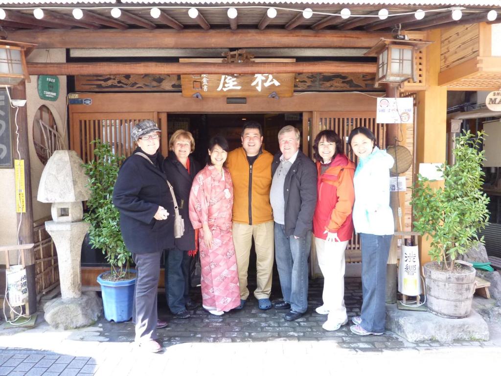 un groupe de personnes debout devant un bâtiment dans l'établissement Senshinkan Matsuya, à Yamanouchi