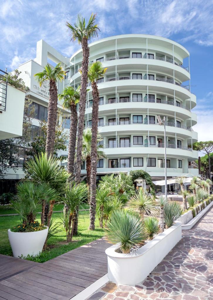 un bâtiment avec des palmiers devant dans l'établissement Hotel Le Palme - Premier Resort, à Milano Marittima