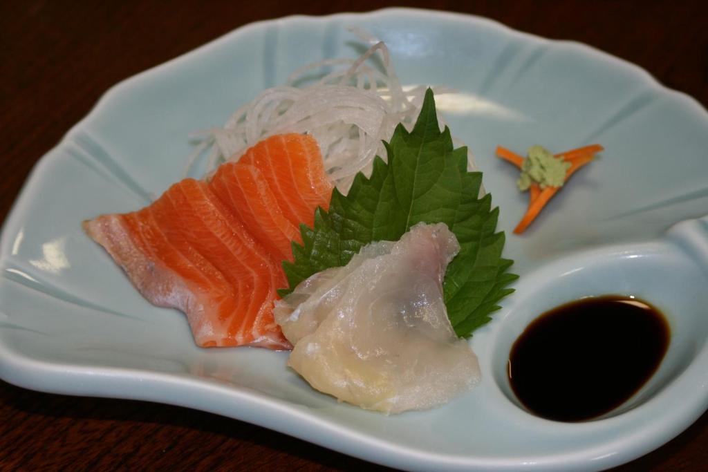 une assiette de nourriture avec du saumon, des nouilles et une sauce dans l'établissement Suisensou, à Takayama
