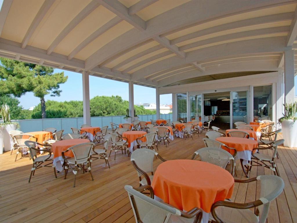 une terrasse vide avec des tables et des chaises. dans l'établissement Hotel Sorriso, à Milano Marittima