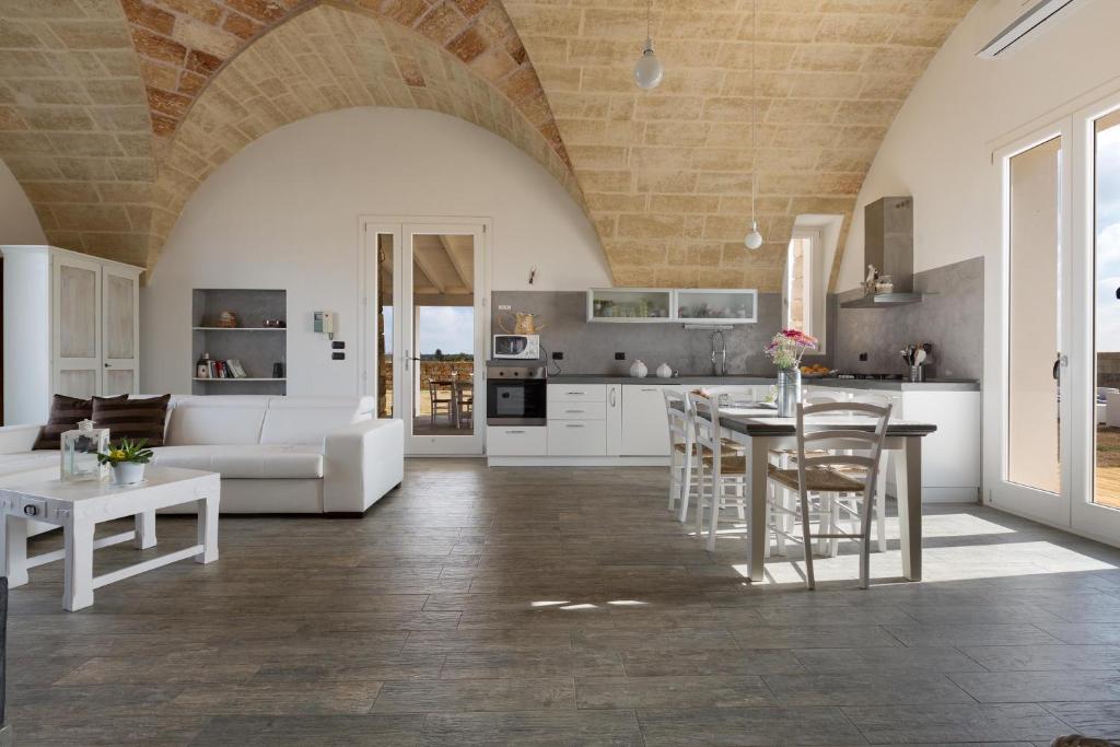 une cuisine et un salon avec une table et des chaises dans l'établissement Villa Toffi by Perle di Puglia, à Acquarica del Capo