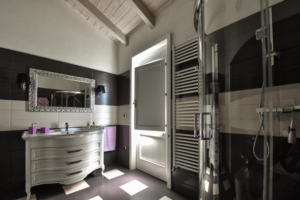 une salle de bain avec un lavabo, une douche et un miroir dans l'établissement Villa Panagias tis Loreto, à Zollino