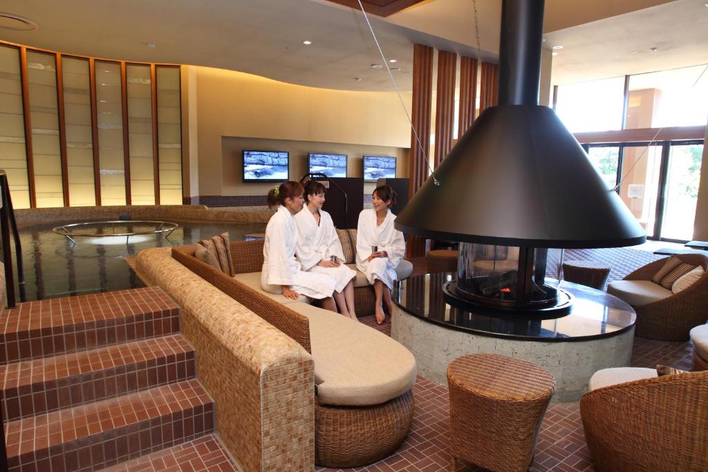 trois filles en uniforme blanc assises dans un hall dans l'établissement Arima Grand Hotel, à Kobe