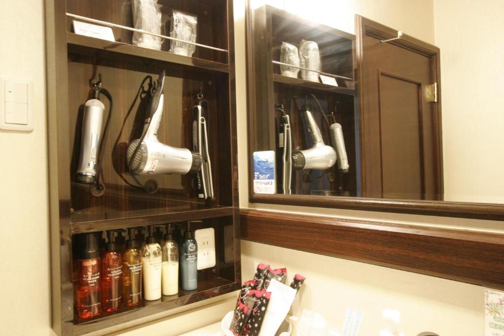 - un miroir au-dessus d'un lavabo dans la salle de bains dans l'établissement Hotel Joy (Adult Only), à Komaki