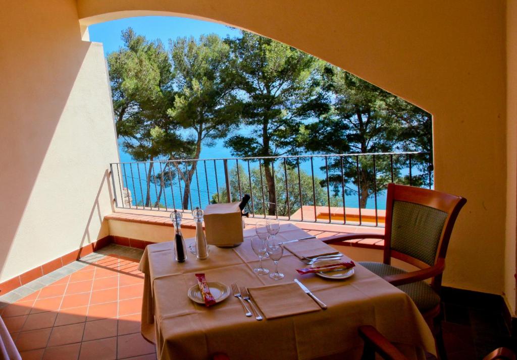 une table et des chaises sur le balcon d'un restaurant dans l'établissement Albergo Filippo II, à Porto Santo Stefano