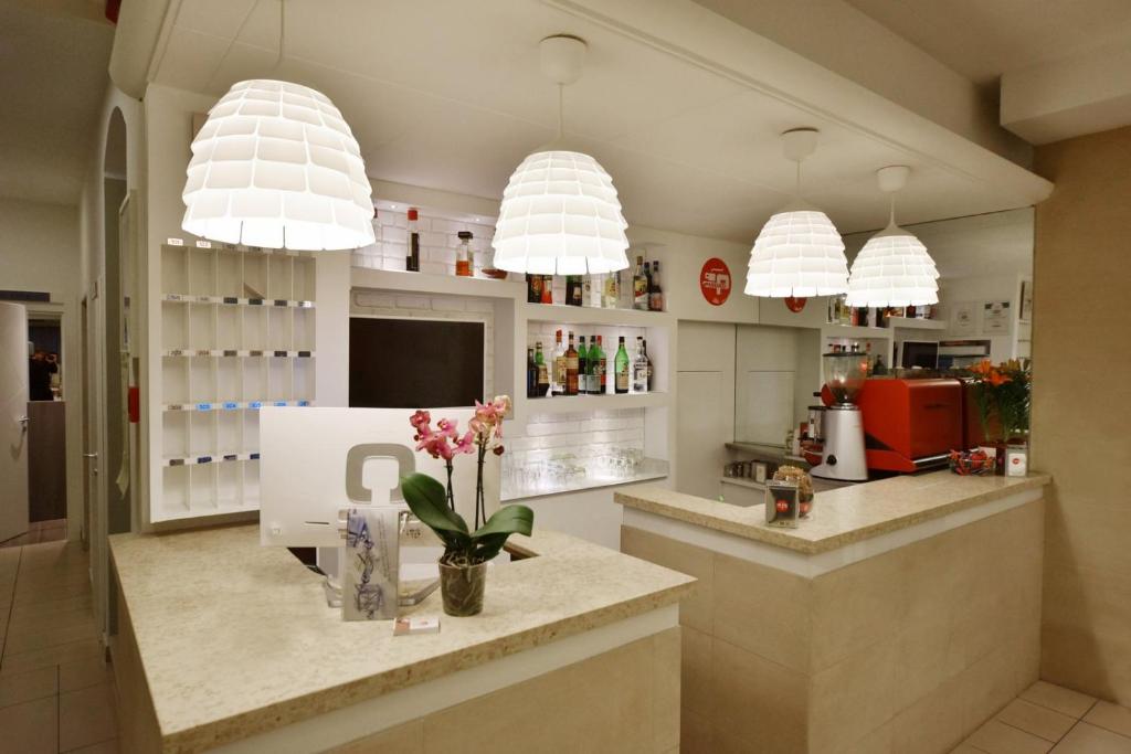 une cuisine avec des lampes suspendues et un comptoir fleuri dans l'établissement Hotel Villa Edda, à Riccione