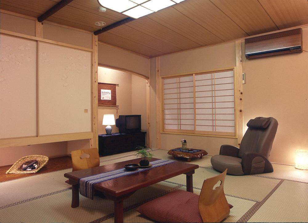 un salon avec une table et une chaise dans l'établissement 旅館かわな -Ryokan Kawana-, à Kimitsu