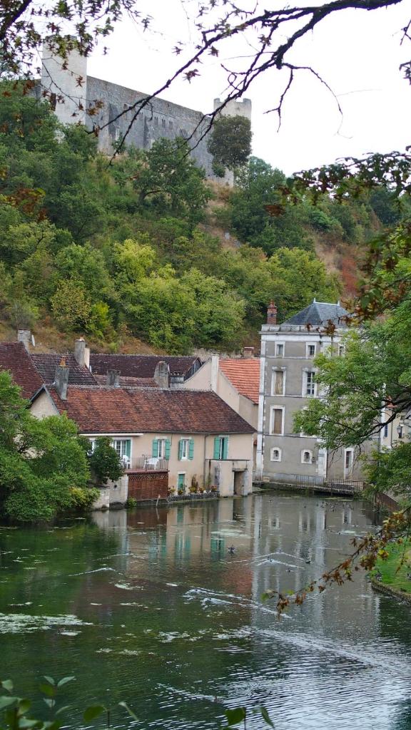 - une vue sur une rivière avec des maisons et des bâtiments dans l'établissement Gite en Forterre, à Druyes-les-Belles-Fontaines