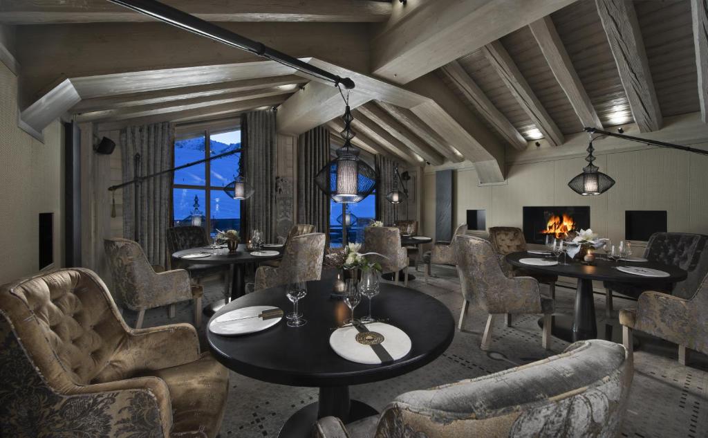 une salle à manger avec tables et chaises et une cheminée dans l'établissement Hotel Le K2 Altitude, à Courchevel