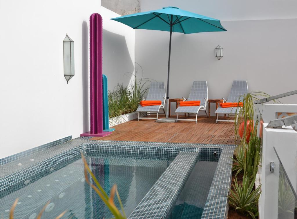 une maison avec une piscine et un parasol dans l'établissement Riad Dar Dar, à Rabat