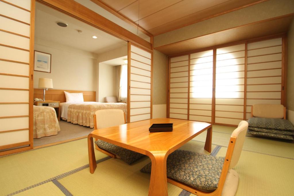 une pièce avec une table et des chaises et une chambre dans l'établissement Hotel Gozensui, à Akankohan