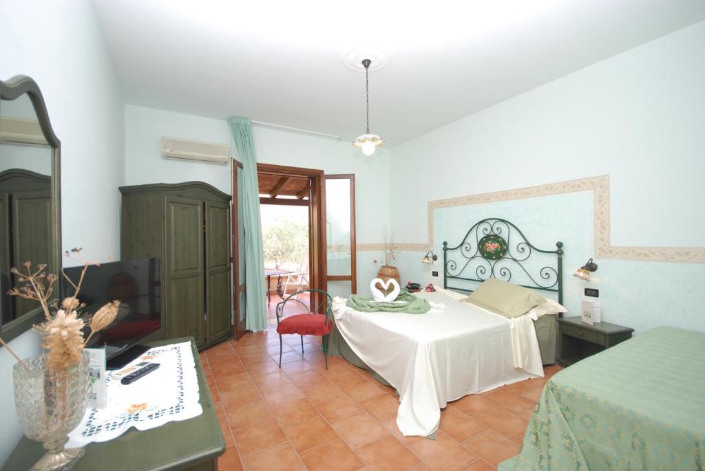 une chambre avec un lit et une télévision dans une pièce dans l'établissement Hotel Oasi da Paolo, à Castelluzzo