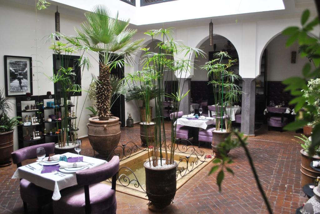 un restaurant avec des tables et des plantes en pot dans une pièce dans l'établissement Ryad Amiran & Spa, à Marrakech