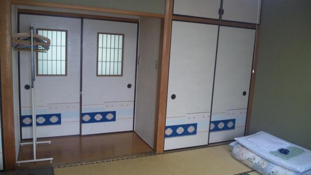 - une chambre avec deux portes coulissantes en verre et un lit dans l'établissement Mizuhokan, à Ise