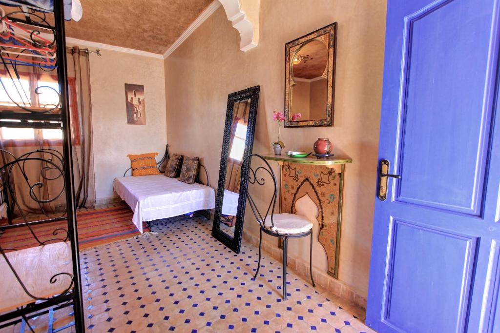 une pièce avec une chambre avec un lit et un miroir dans l'établissement Maison du Soleil, à Tiznit