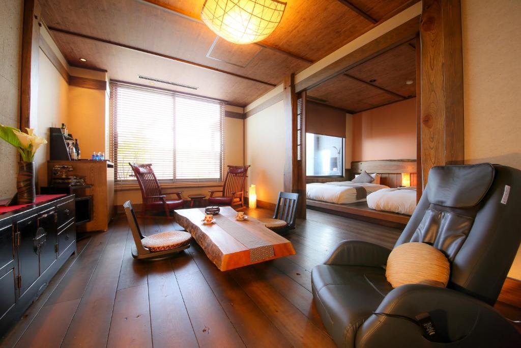 Cette chambre comprend un lit, un canapé et une table. dans l'établissement 旅館かわな -Ryokan Kawana-, à Kimitsu