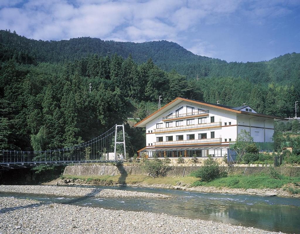 un grand bâtiment avec un pont sur une rivière dans l'établissement Watarase Onsen Hotel Yamayuri, à Hongu 24 autres photos