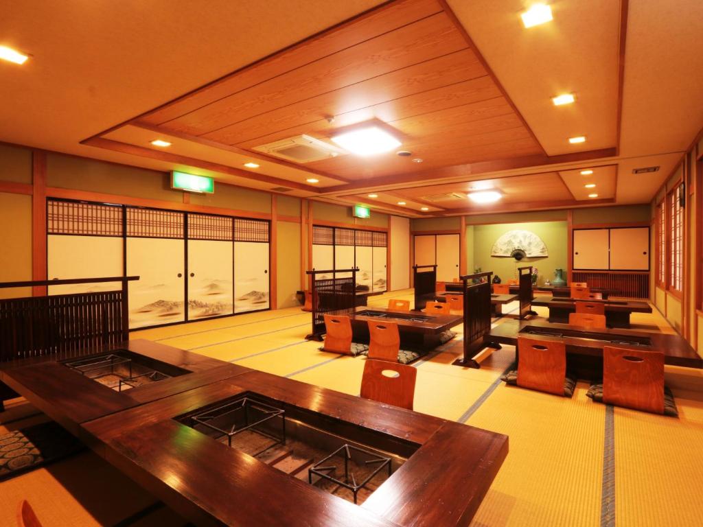 une grande pièce avec des tables et des chaises en bois dans l'établissement Yunohirakan, à Takayama