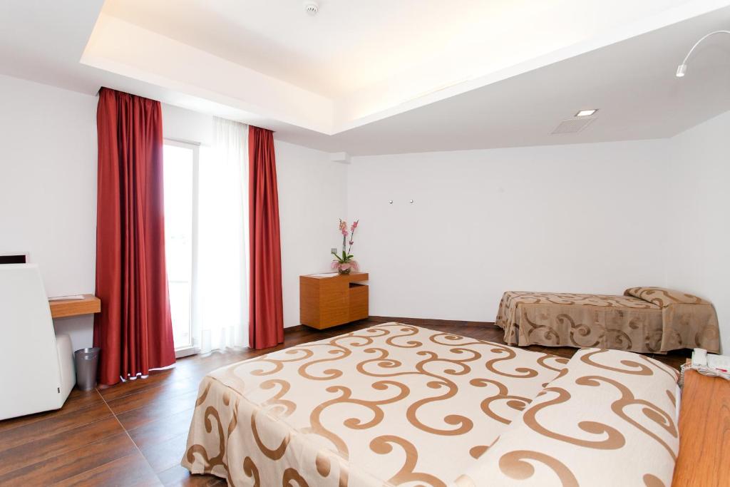 - une chambre avec 2 lits et des rideaux rouges dans l'établissement Hotel Scialì, à Vieste 102 autres photos