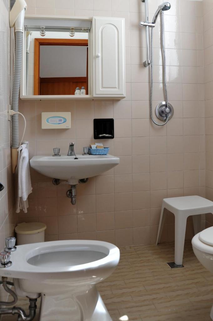 une salle de bain avec un lavabo et des toilettes dans l'établissement Hotel Reno, à Lido di Jesolo