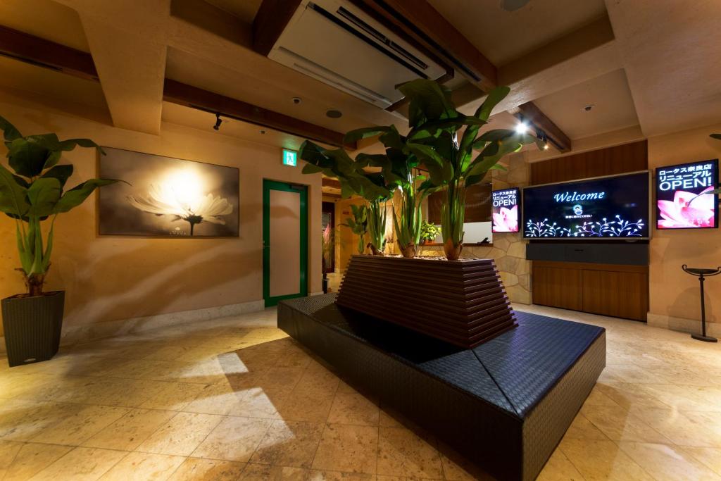 - un hall avec un banc orné de plantes et une télévision dans l'établissement Hotel Lotus Nara (Adult Only), à Nara