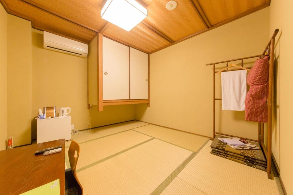 Cette chambre comprend une cuisine équipée d'un réfrigérateur et d'une table. dans l'établissement Kyo no Yado Sangen Ninenzaka, à Kyoto
