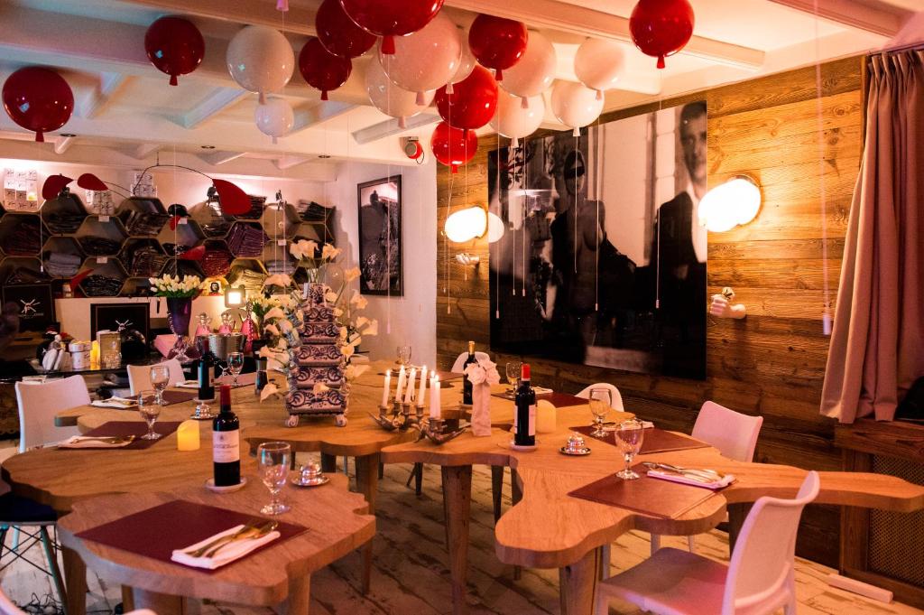 une salle à manger avec des tables en bois et des ballons rouges dans l'établissement Snow Lodge Hotel Courchevel 1850, à Courchevel 37 autres photos