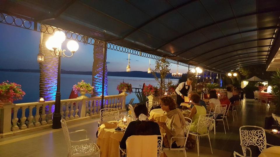un groupe de personnes assises à des tables dans un restaurant dans l'établissement Hotel Lido - Beach and Palace, à Bolsena 126 autres photos
