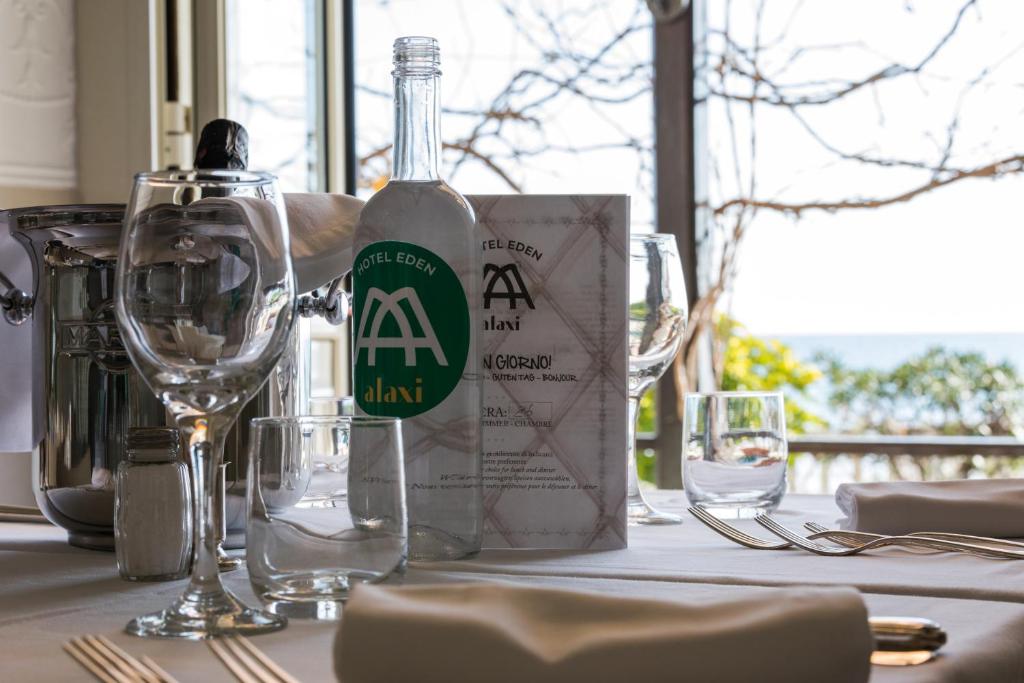 une bouteille de vin posée sur une table avec des verres dans l'établissement Hotel Eden Alaxi Hotels, à Alassio