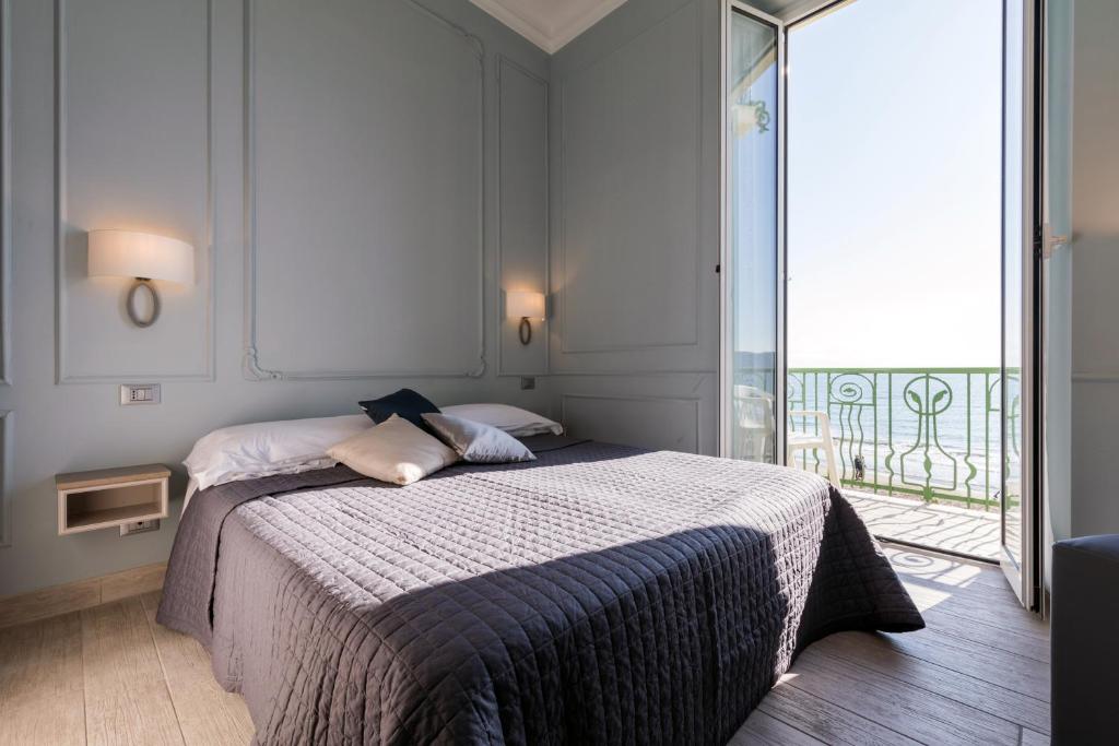 une chambre avec un lit et un balcon dans l'établissement Hotel Eden Alaxi Hotels, à Alassio