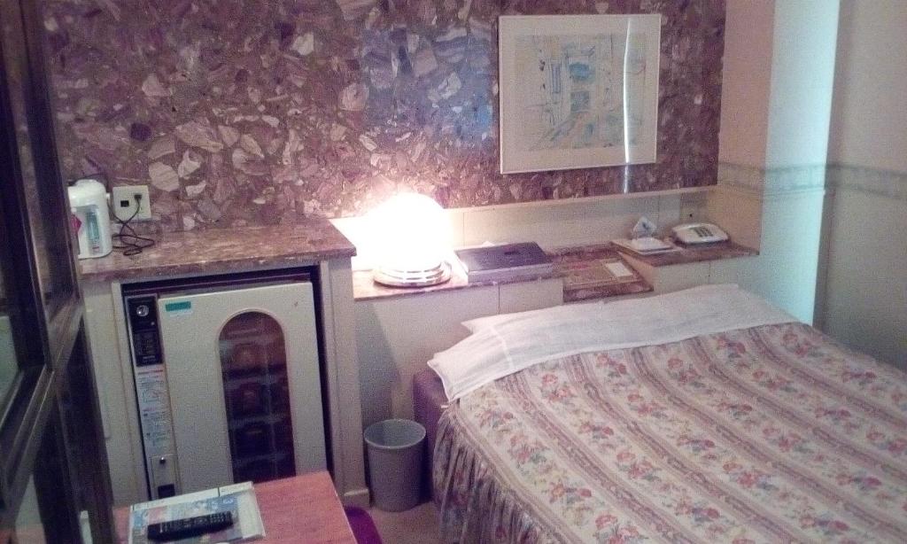 une chambre avec un lit et une table avec une lampe dans l'établissement Hotel Ikoma (Love Hotel), à Nagasaki