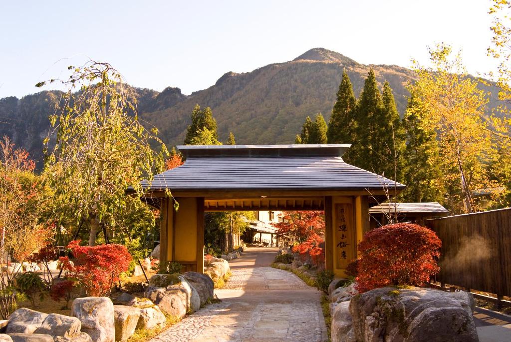 une porte dans un jardin avec des montagnes en arrière-plan dans l'établissement Miyama Ouan Kyoritsu Resort, à Takayama 72 autres photos