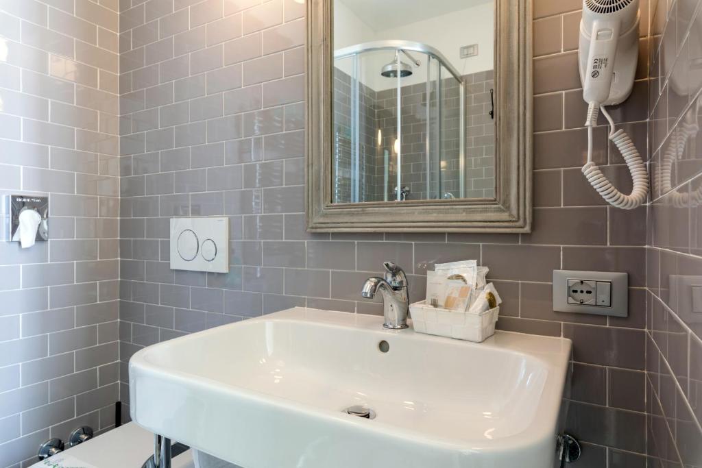une salle de bain avec un lavabo blanc et un miroir dans l'établissement Hotel Eden Alaxi Hotels, à Alassio 52 autres photos